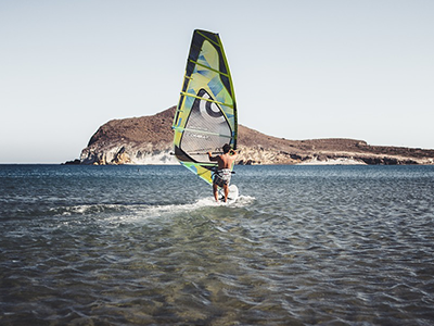 Windsurfer at the beach in shallow water